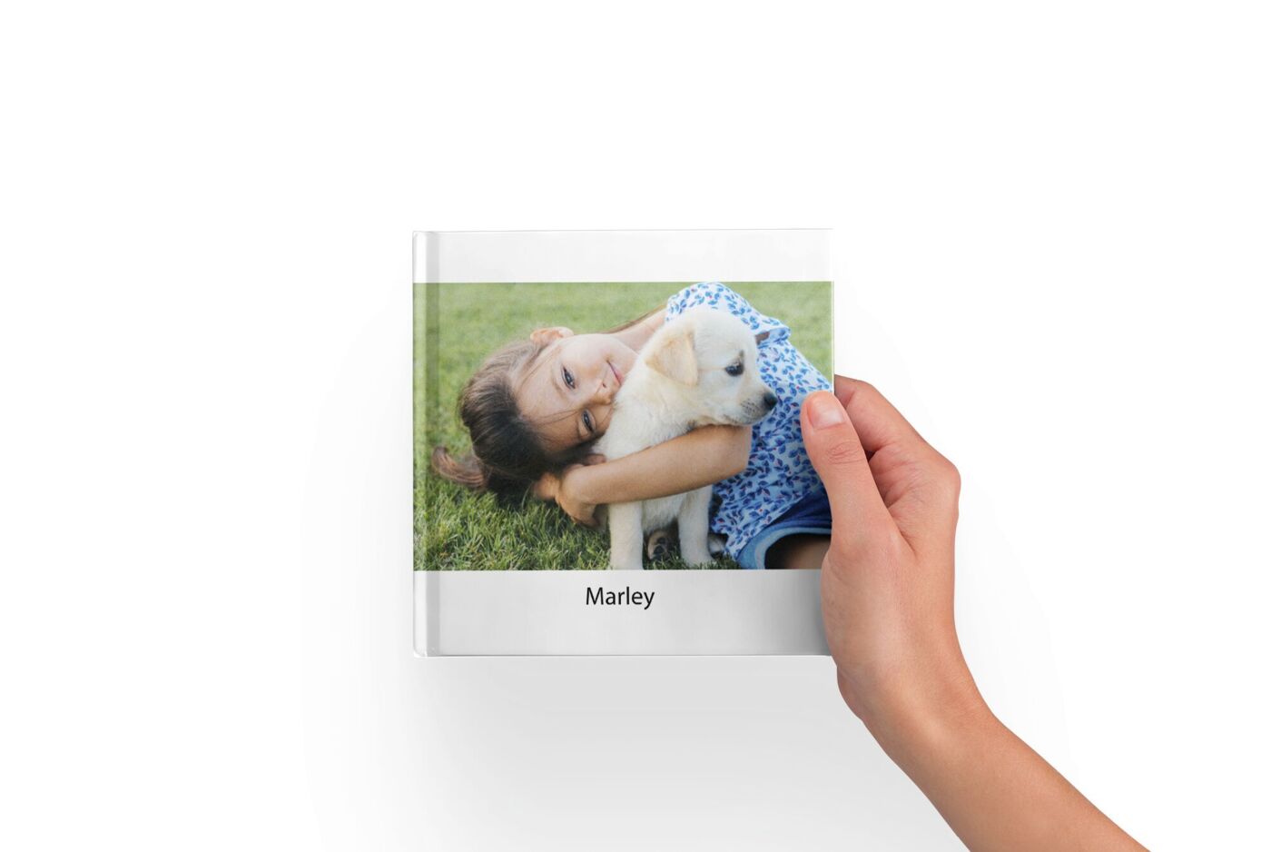 Livre photo format petit carré tenu entre les mains