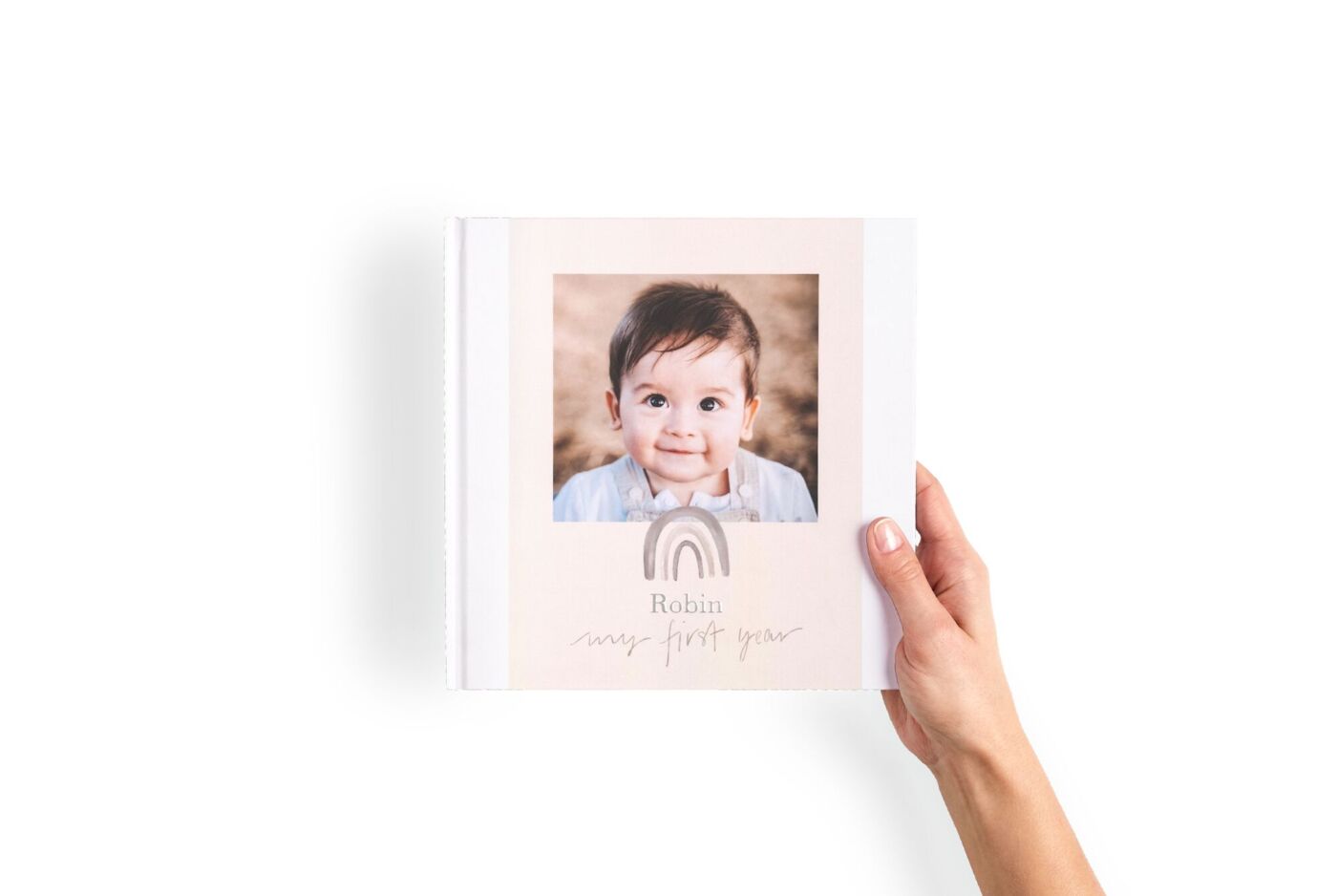 Livre photo format carré tenu entre les mains